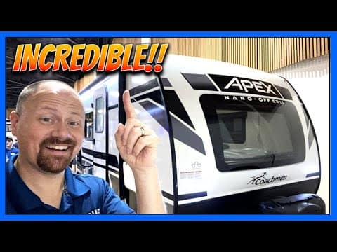 A man is pointing to an incredible Coachmen RV.