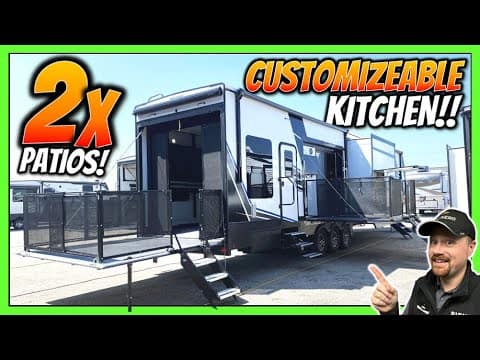A man is standing in front of a Keystone RV with a kitchen.