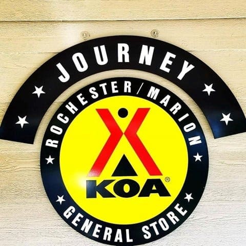 Located within the busy campground in Rochester, a sign proudly displays the words "Journey Rochester Marion KOA General Store.