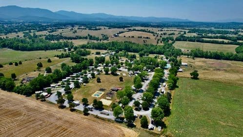 Spacious Skies Campgrounds provide an exclusive camping area surrounded by trees and mountains, offering breathtaking aerial views.