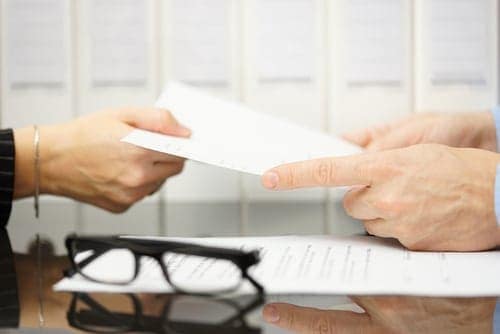 A businessman handing a document to another person at Bolney Farm.