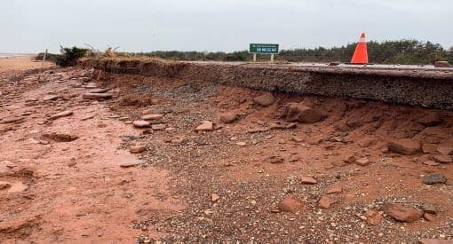 A road with a large amount of sand and rocks on it in P.E.I. National Park.
