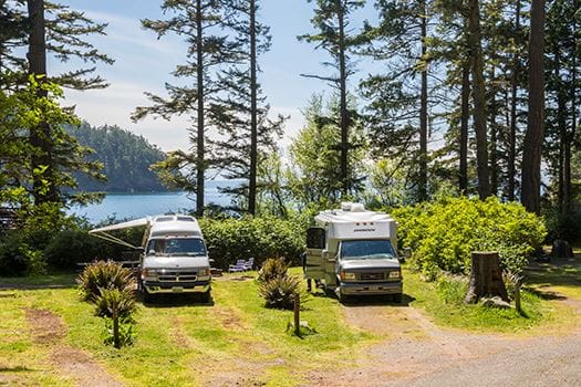 Three RVs parked in a grassy area near Deception Pass State Park.