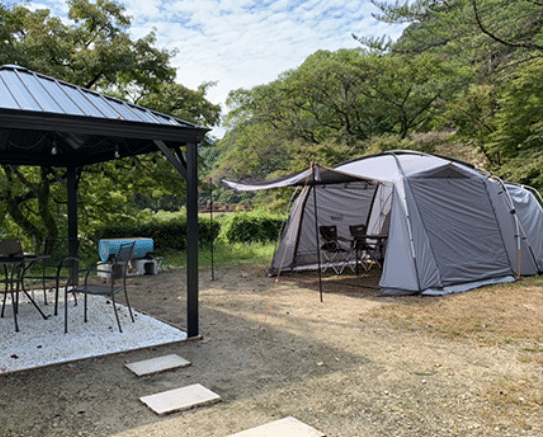 A tent is set up in a wooded area, boosting local tourism and serving as the Aichi Gateway for exploring the enchanting Korankei.