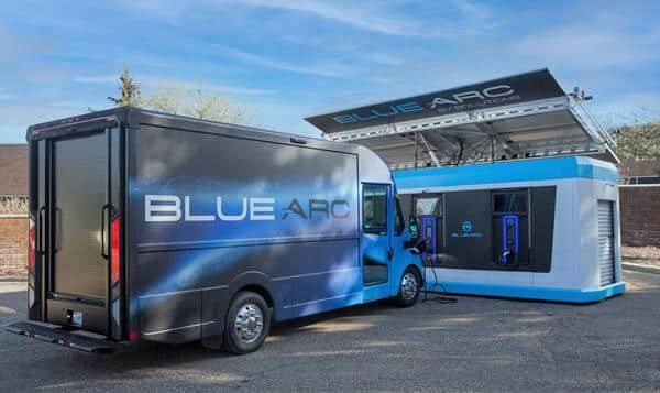A Blue Arc truck is parked in front of a building, showcasing the innovative technology of Blue Arc EV Solutions.
