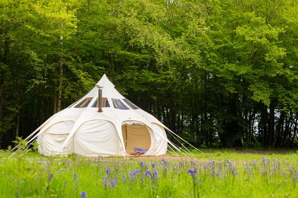 A unique tepee tent nestled in a tranquil wooded area.