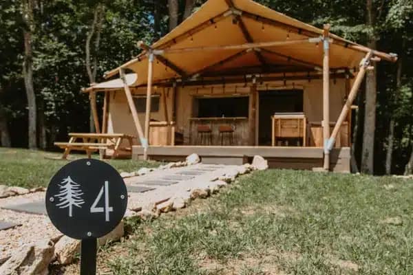 A retro tent with a number on it in the woods.
