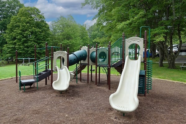 A playground with a slide and swings in Woodland Hills park.