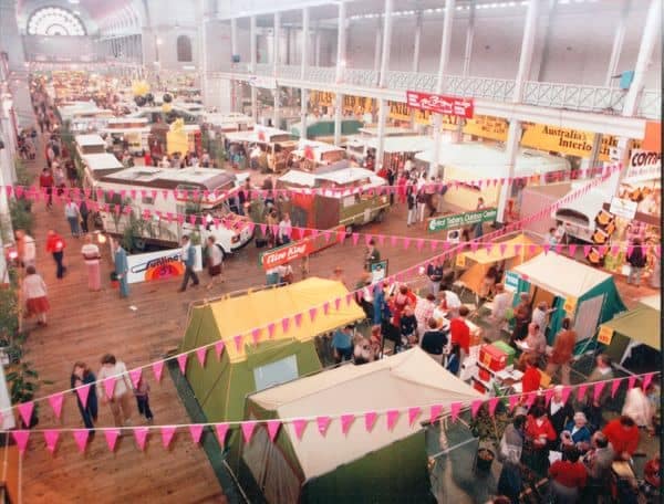 A Victorian Caravan Show featuring major announcements and launches takes place in a large hall filled with many tents and stalls.