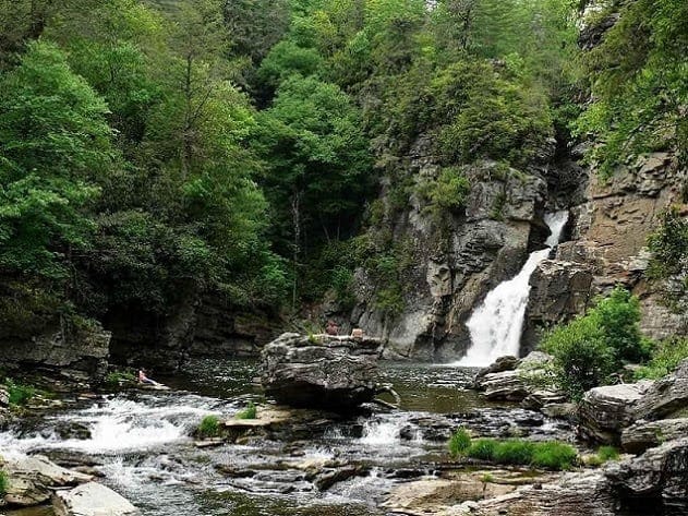 Spacious Skies Campgrounds acquires a waterfall in the middle of a wooded area.