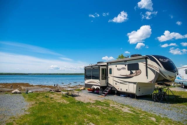 An RV parked next to a body of water at Bar Harbor/Oceanside KOA.