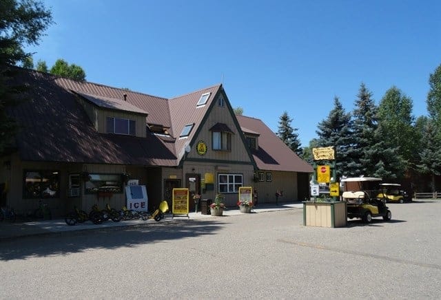 A yellow building with a golf cart parked in front of it at Steamboat KOA.