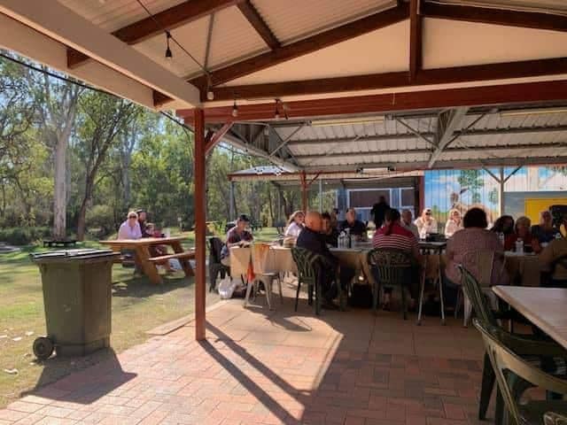 A group of people sitting at tables in Nature's Lap, a covered area.
