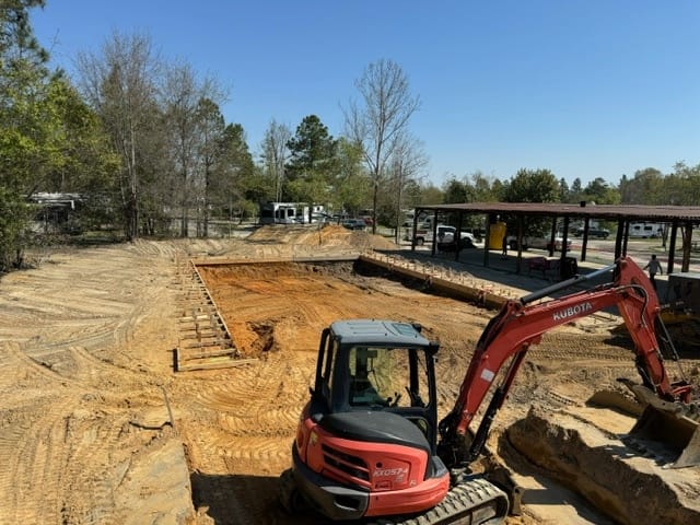 Construction site with an auto draft excavator near the foundation work.