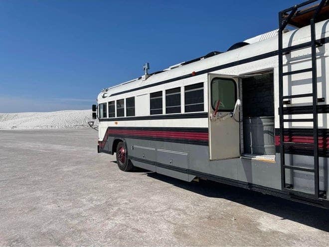An RV is parked in the middle of a desert.