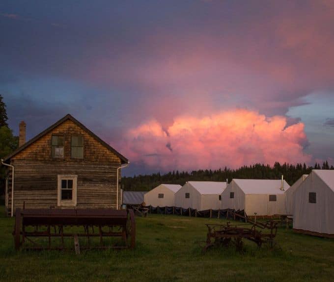 A group of tents at a Métis Cultural Destination in Canada, set against the backdrop of a pink sky.