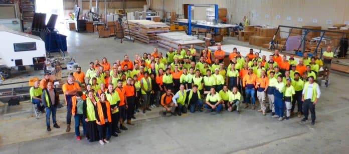A group of government officials in orange vests posing for a photo.