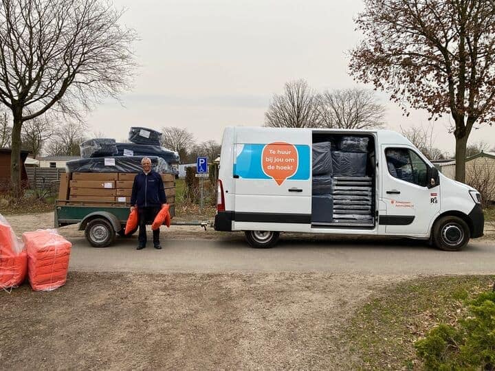 A man standing next to an Estivotravel van with a trailer.