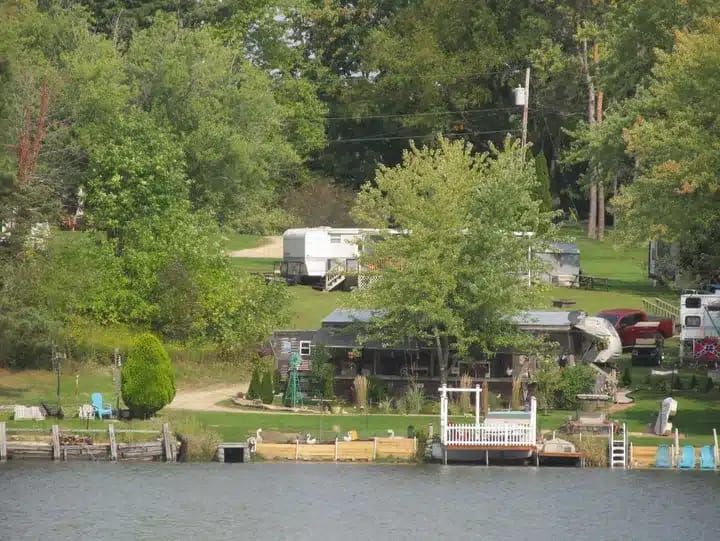 Paradise Lake Park Campground, an Rv park in Ohio, offers a scenic backdrop with a picturesque lake and a boat gently resting in the background.