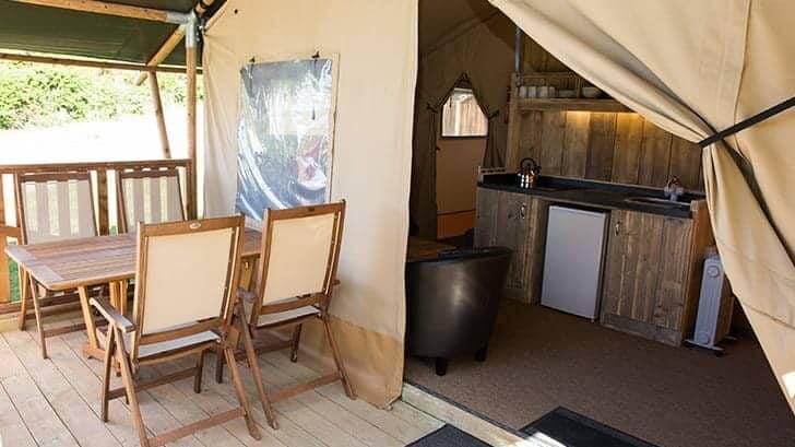 Step inside the enchanting Newquay Holiday Park, a Cornish coastal haven where a cozy tent awaits you. Equipped with a table and chairs, this tranquil retreat provides the perfect setting