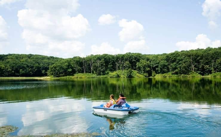Two people riding in a small boat on a lake at Crowder State Park.