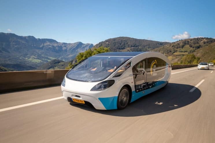 A solar powered car Wraps Up down a mountain road.