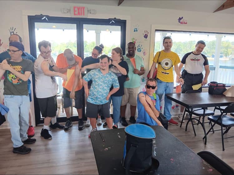 A group of people from New Orleans North Shore standing around in a room while planning exciting and inclusive outdoor activities under the warm sun.