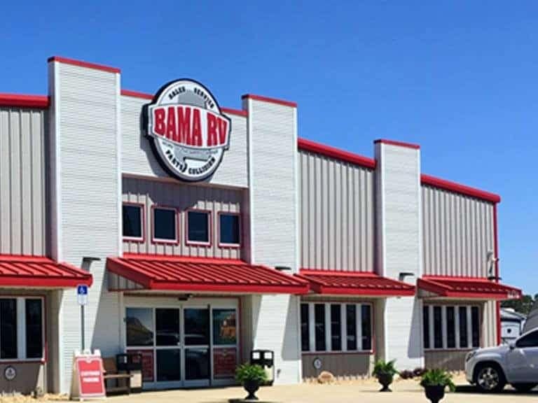 A red and white building with cars parked in front of it, offering Bama RV donations.