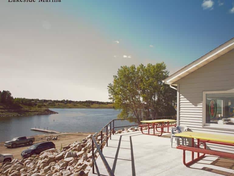 A boat sits peacefully in a serene lake scene at North Dakota's Lakeside Campground.