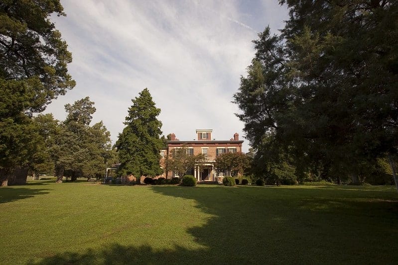 A large brick house sits in the middle of a grassy field in Chippokes State Park.