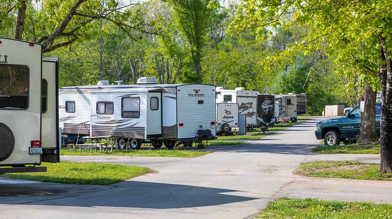 A row of RV trailers parked in a RV Park.