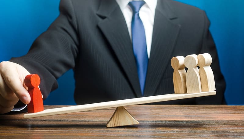A businessman in Strathcona County is balancing two wooden figures on a seesaw while opposing the concerns of residents.