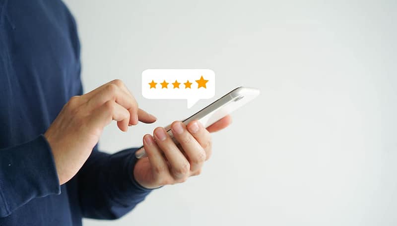 A man holding a smartphone with a luxury star rating.