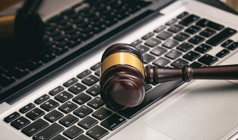 A wooden gavel sits on top of a laptop, symbolizing the Auction Donations or the March Conference organized by CCRVC.