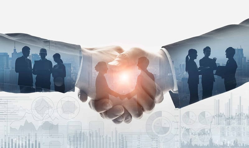 A group of business people shaking hands in front of a Michigan business background.