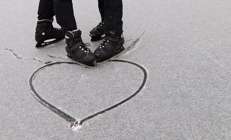 Two people on ice skates at the Heart-Embedded Ice Rink in the shape of a heart.
