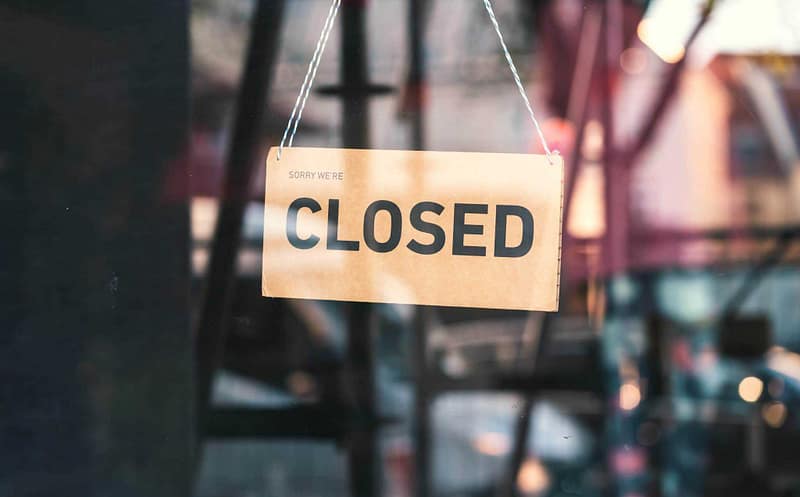 A closed sign hanging from the window of a business.