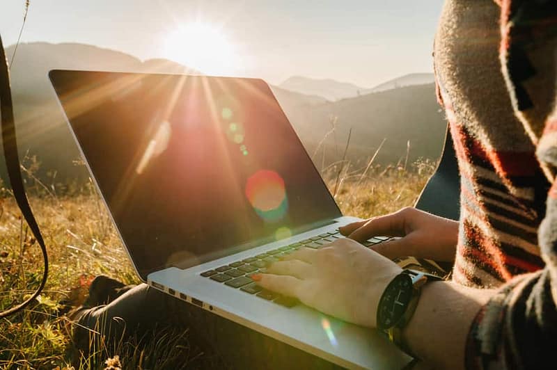 A woman working on a laptop at the Glamping Show USA conference in the mountains of Colorado.