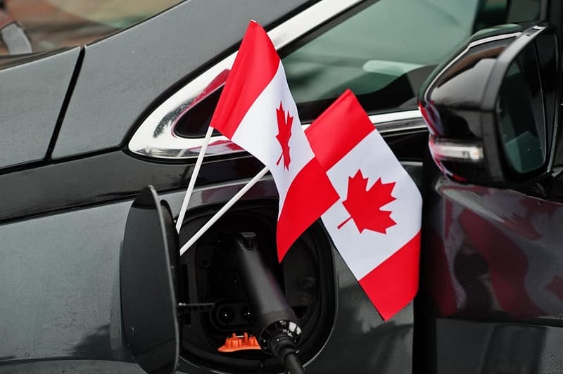 Two Ontario flags hanging from a car's receptacle.