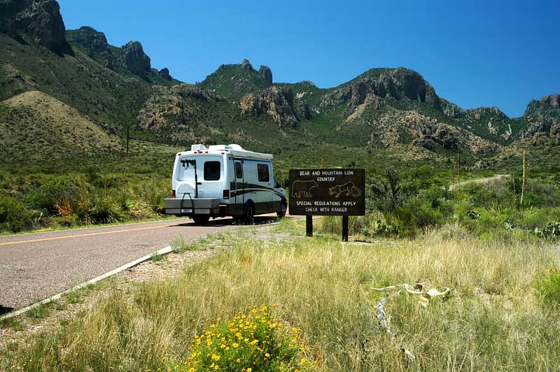 A legal rv parked on the side of a road with mountains in the background, serving as a unique marketing opportunity for TACO enthusiasts.