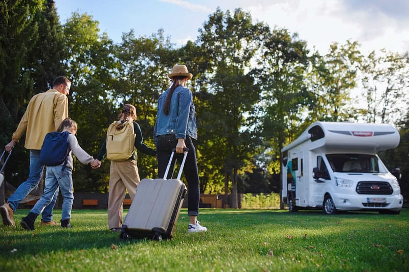 Increase: A family is walking with luggage in front of an rv, suggesting a growing interest in caravans.