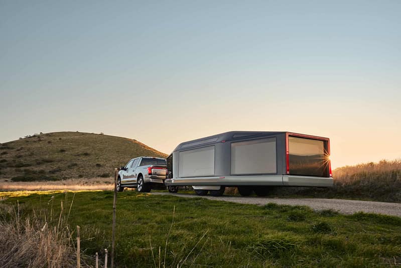 America's First all-electric travel trailer is parked on the side of a road.