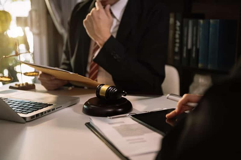 A lawyer is sitting at a desk during Congressional hearings.