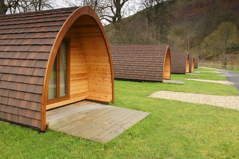 A row of Moira glamping pods in a grassy area, perfect for local tourism.