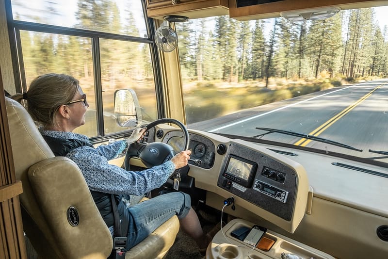 A woman driving an rv on a highway.
