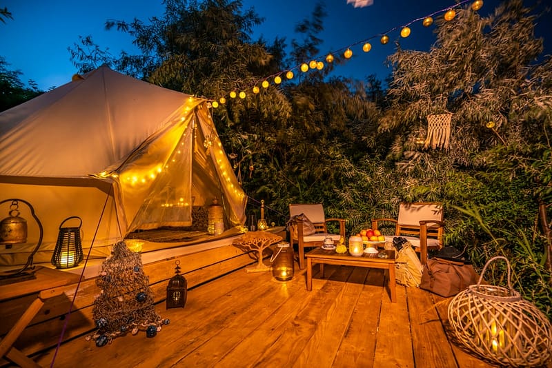 A wooden deck with a tent and lanterns will be showcased at the Glamping Show USA 2021, an event dedicated to promoting the glamping business in the Americas. Don't miss