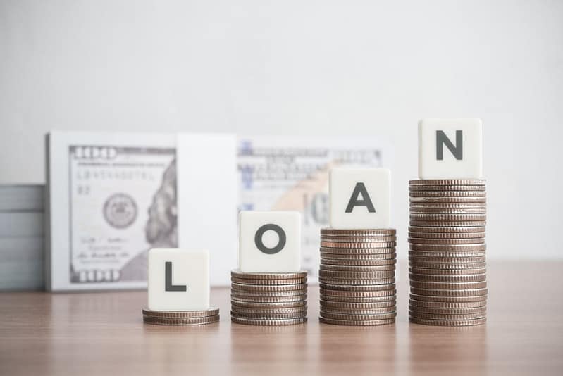 Stacks of coins with the word loan on top of them.