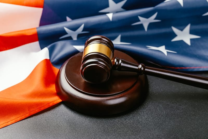 A gavel and an American flag on a black background, symbolizing the significance of pending infrastructure bill and RV industry priorities.