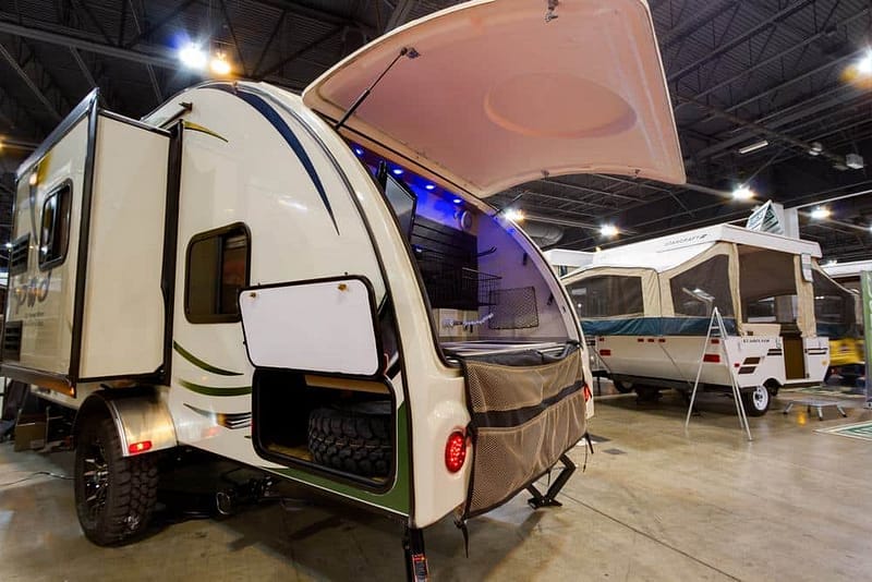 A small RV showcased at the Northwest Ohio Camp & Travel RV Show in a convention center.