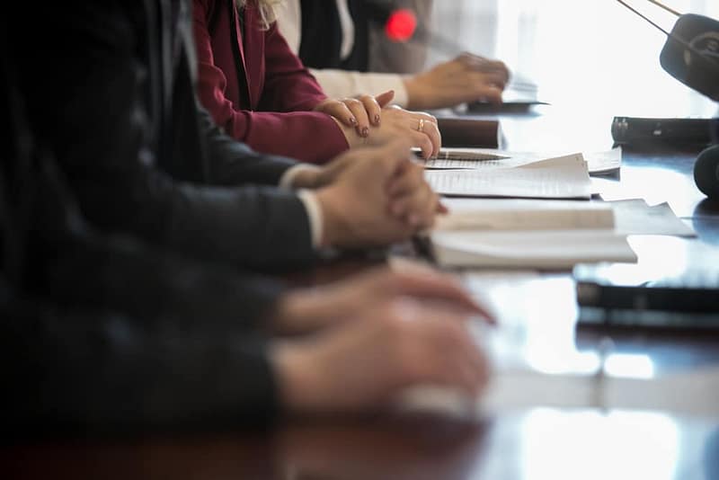 A group of business people sitting at a conference table engaged in a controversial discussion.
